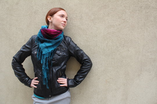 Beautiful redhead young woman near a wall