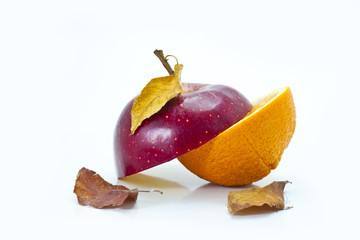Apple cut on half with orange on white background with leafs