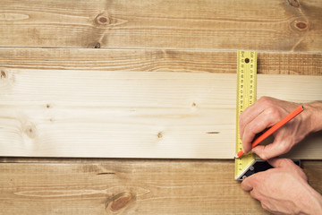 Carpenter with a measuring tool and a pencil