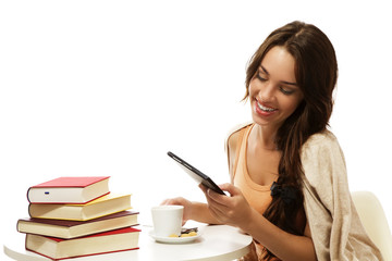 glückliche junge frau liest ebook mit büchern und kaffee