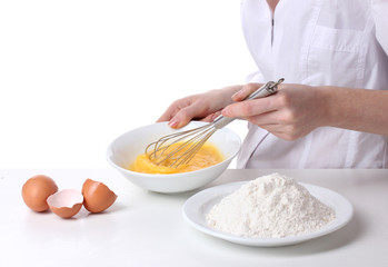 Female hands mixing eggs in bowl isolated on white