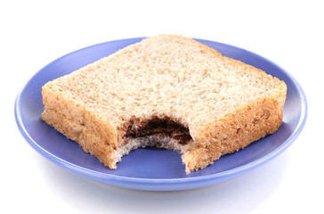 Bitten sandwich with chocolate on plate isolated on white