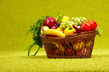 Fresh vegetables in basket  on green background