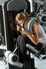 Fototapeta na wymiar Young woman at fitness center exercise abdominal