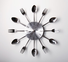 Clock design with spoons and forks over white background