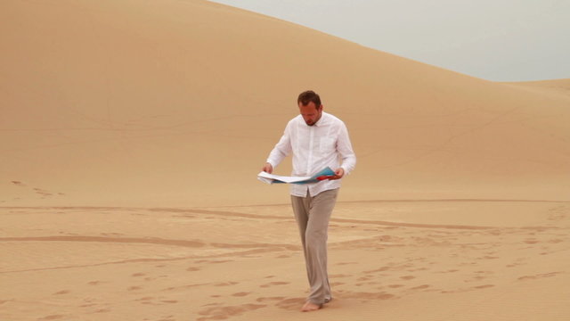 Lost man looking at map in the desert