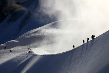 Een groep alpinisten op weg naar de mont blanc bij zonsopgang.