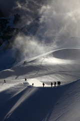 A group of alpinists on their way to the mont blanc at dawn. - obrazy, fototapety, plakaty