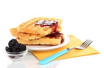 Tasty waffles with jam on plate isolated on white