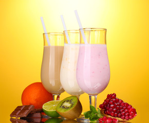 Milk shakes with fruits and chocolate on yellow background