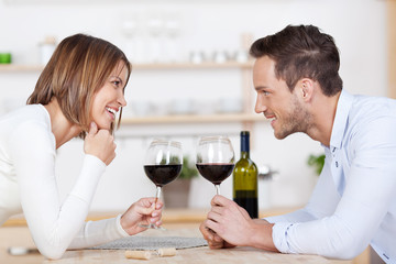 junges glückliches paar stößt mit rotwein an