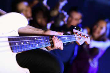 Fototapeta premium Young guitar player performing in night club
