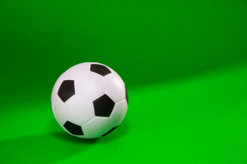 Small soccer ball over green background