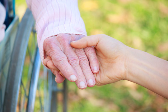 Senior and Young Women Holding Hands