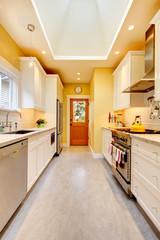 Yellow kitchen with white cabinets and stove.