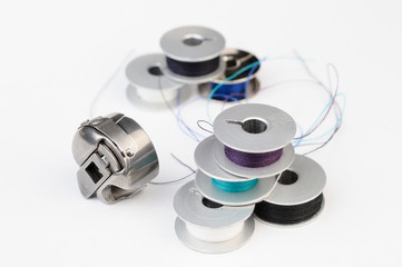 Tailor tools: Metal bobbins of thread and sewing machine shuttle