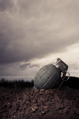 green grenade on a battlefield at dusk