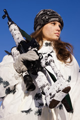 Fototapeta na wymiar Sniper girl in white camouflage on a blue sky background