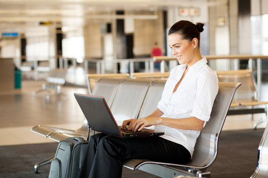 young woman using laptop computer at airport