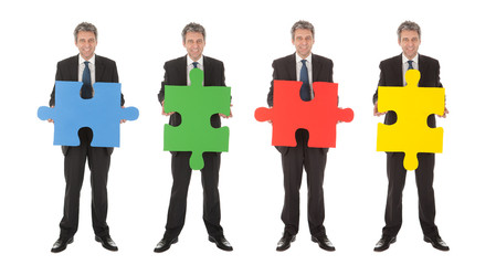 Obraz premium Group of business people holding jigsaw puzzle