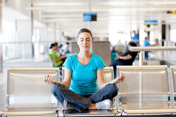 beautiful young casual woman doing yoga meditation at airport