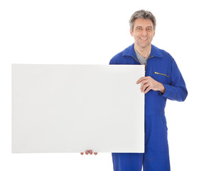 Portrait of automechanic holding empty banner