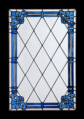 An old ornate window with blue design on the glass.