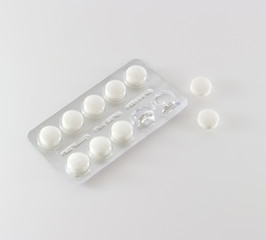 Pack of pills and two tables isolated on white background