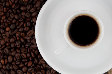 A cup of coffee on the background of coffee beans