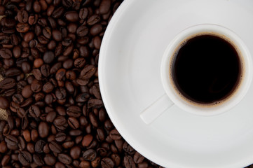 A cup of coffee on the background of coffee beans