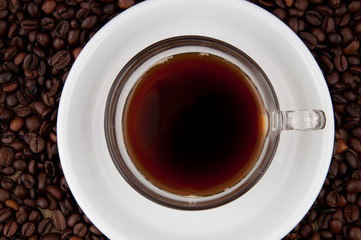 A cup of coffee on the background of coffee beans