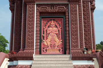 Giant wood sculpture on the door in Thai pagoda .