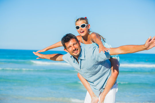 Father and his daughter having fun on beach