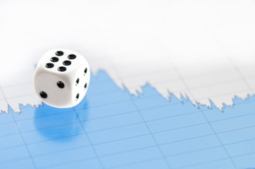 White dice on digital screen with financial chart