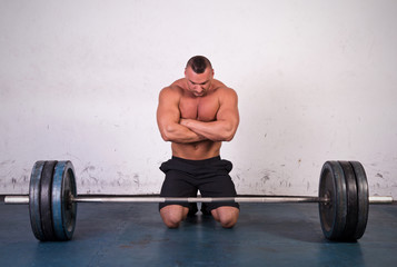 Strong man preparing to lift a heavy dumbbell