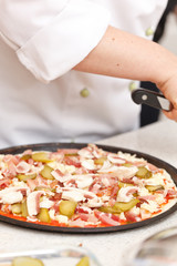 chef making pizza at kitchen