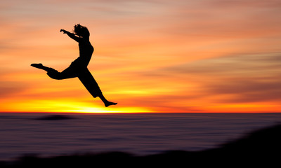 silhouette of girl jumping in sunset