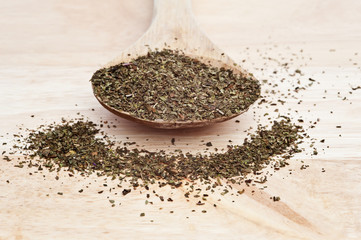Chopped mint on wooden serving spoon with selective focus