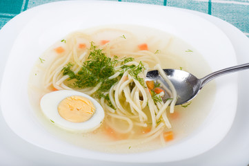 Tasty chicken clear soup with egg in plate