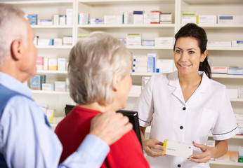 Obraz premium American pharmacist dispensing to senior couple