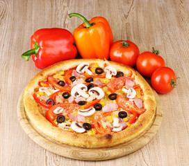 Aromatic pizza with vegetables on wooden background