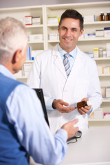 American pharmacist with senior man in pharmacy