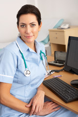 British nurse sitting at desk at work