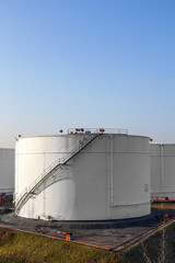white tank in tank farm with blue sky