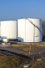 Obraz premium white tank in tank farm with blue sky