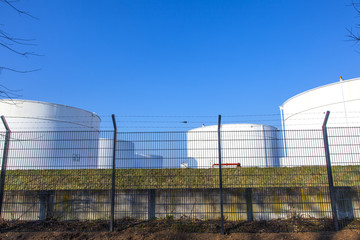 white tank in tank farm with blue sky