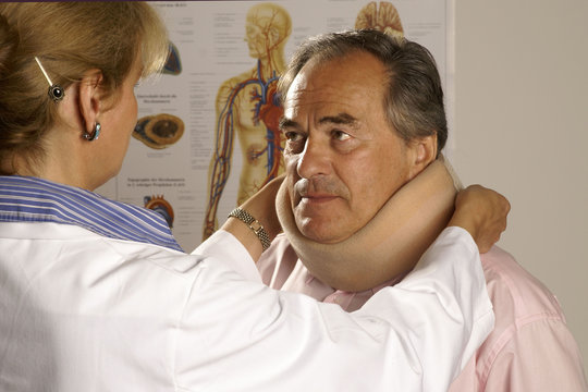 &Auml;rztin legt einem Patienten eine Halskrause an