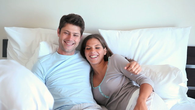 Smiling couple in their bed