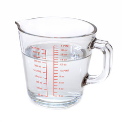 Water in glass measuring cup isolated on white background