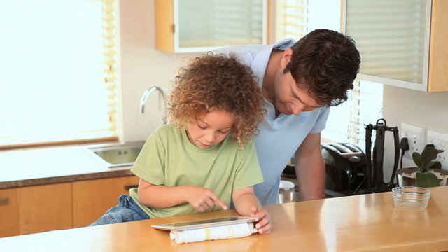 Boy using a ebook with his father